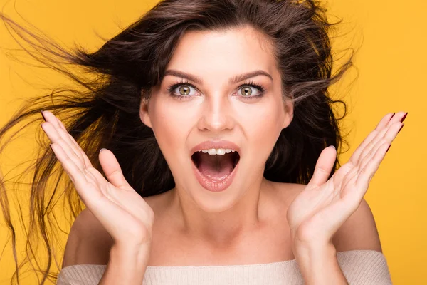 Portret van brunette meisje op gele achtergrond. — Stockfoto