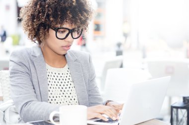 Dizüstü bilgisayarda çalışan zarif Afrikalı-Amerikalı kadın.