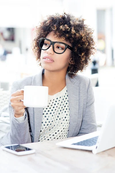 Elegante african american vrouw drinken koffie, werken. — Stockfoto