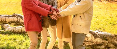 Dört kişinin elleri üst üste bindi. Bir grup insanla arkadaşlık kavramı.