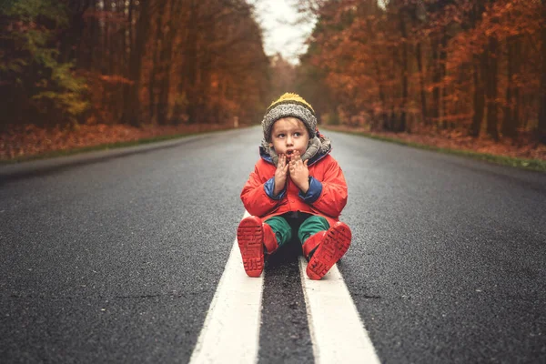 Konceptuell Bild Liten Rädd Pojke Sitter Ensam Asfaltgatan Mellan Höstträd — Stockfoto