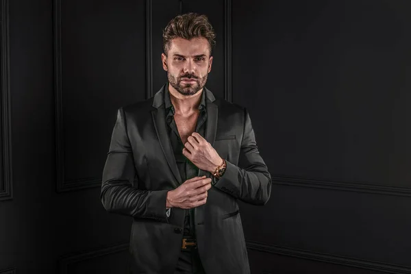 Elegantní Pohledný Muž Pózující Černém Módním Obleku Dívající Kamery Studio Stock Snímky