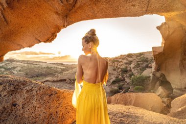 Gün doğarken dağlardaki güzel kaya oluşumları üzerine şehvetli sakin bir kadın. Farkındalık, doğa konseptinde meditasyon. Romantik kız. Arka plan. 
