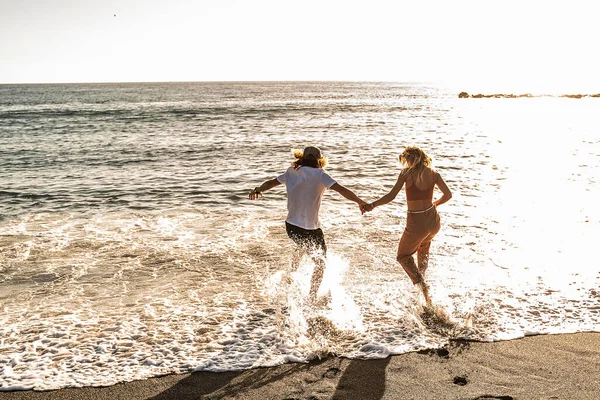 Coppia Che Corre Una Spiaggia Sabbiosa Insieme Tenendosi Mano Divertendosi — Foto Stock