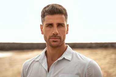 Yakışıklı adam kameraya bakıyor. Açık havada duran güzel gözlü İtalyan 'ın güzel portresini kapat.. 