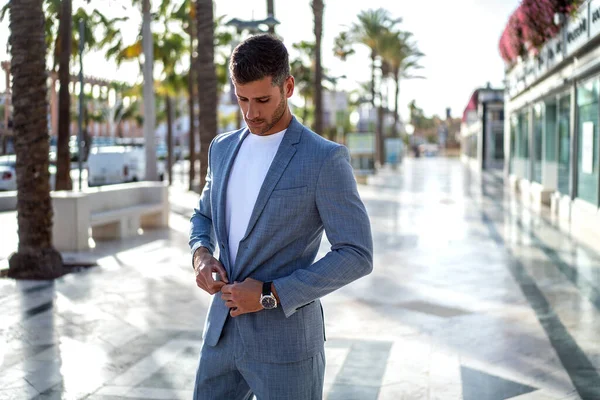 Yakışıklı İtalyan bir adam şık şık bir takım elbise giyerek şehir sokaklarında yürüyor. Modern iş adamı.