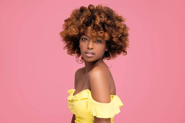 年轻迷人的非洲美女的美丽的女性五彩斑斓的肖像 有着卷曲的发型和迷人的夏季妆容 粉红粉刷工作室背景 大量的复制空间 — 图库照片