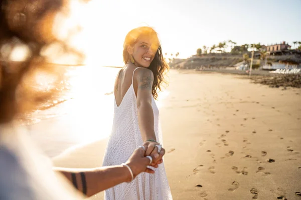 彼を見て 夕日の間にビーチを歩いて 彼女のボーイフレンドの手を握って素敵な笑顔の美しい女性 夏の島の振動 愛は空気中にあります 本物の人々の生活 — ストック写真