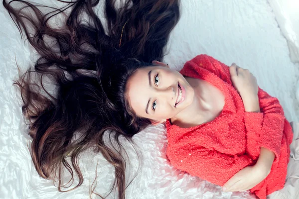 Adolescente chica en la cama sonriendo — Foto de Stock