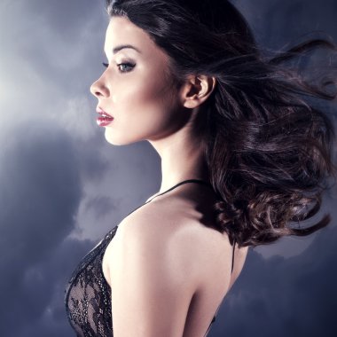 Seksi esmer kadın iç çamaşırlarıyla poz veriyor.