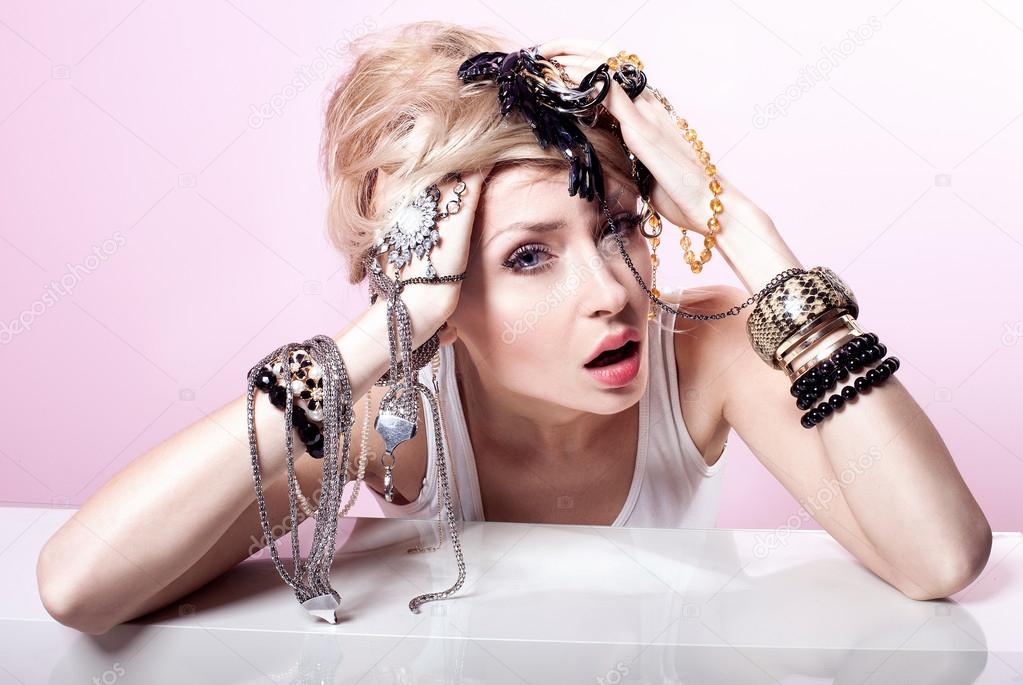 Blonde girl with jewelery posing.
