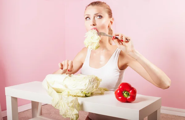 Aantrekkelijke blonde vrouw groenten eten. — Stockfoto