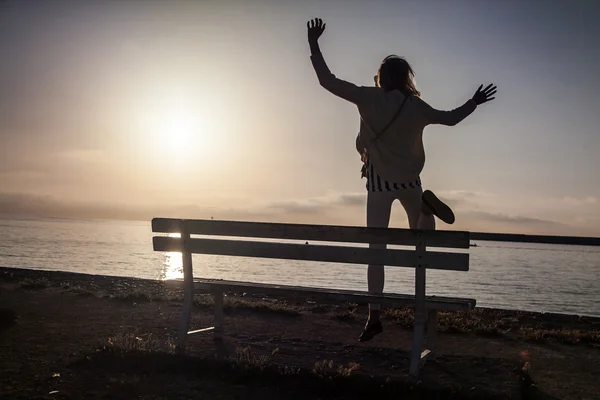 Flickan hoppar över soluppgången. — Stockfoto