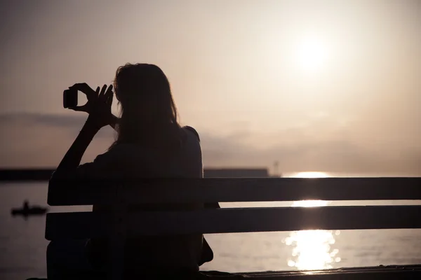 Chica tomando fotos de la puesta del sol . —  Fotos de Stock