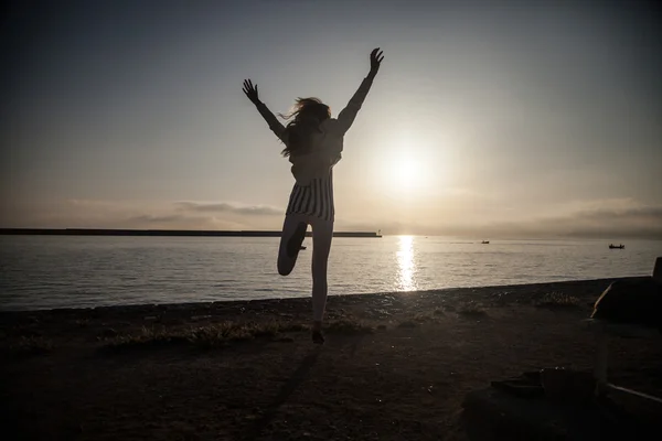 Girl jumping over sunrise. — Stock Photo, Image