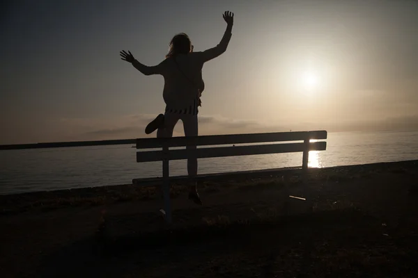 Flickan hoppar över soluppgången. — Stockfoto