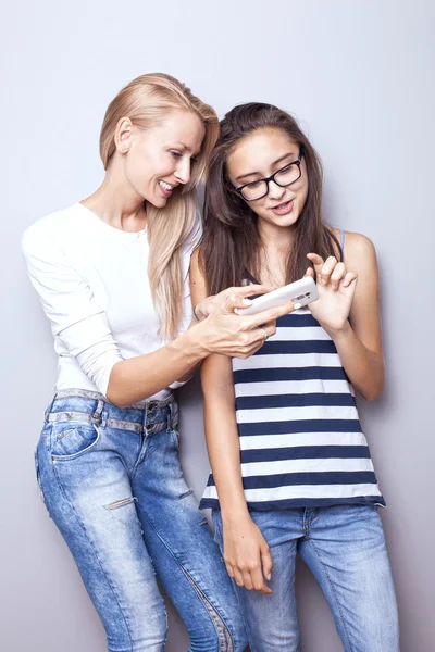 Zwei Schwestern posieren mit Handy. — Stockfoto