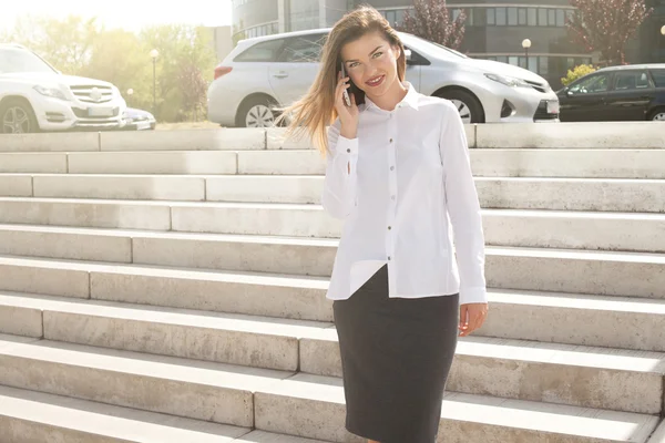 Elegante jonge zakenvrouw praten via de telefoon. — Stockfoto