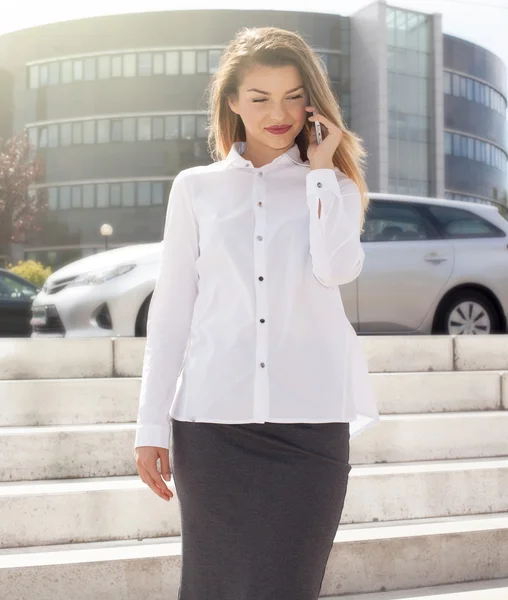 Elegante jonge zakenvrouw praten via de telefoon. — Stockfoto