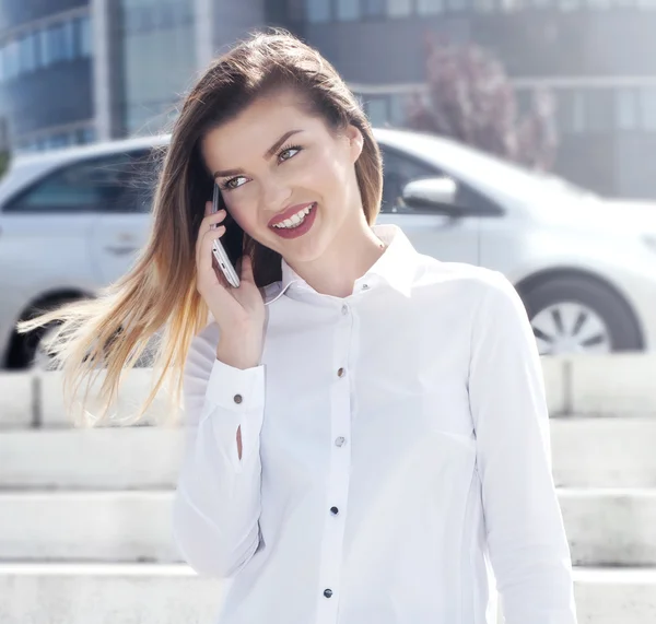 Elegant young businesswoman talking by phone. — Stock Photo, Image