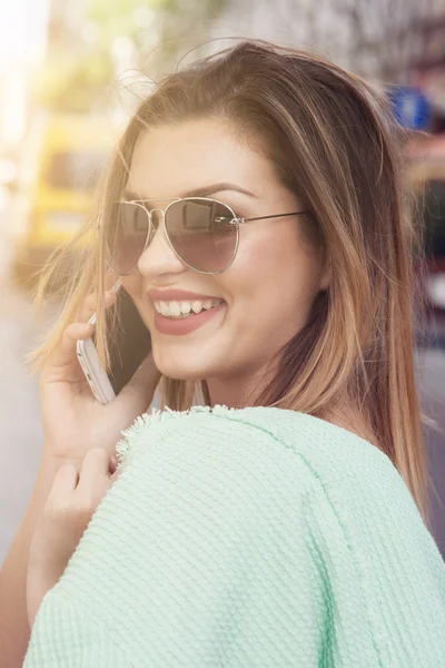 Glückliche junge Frau, die per Handy spricht. — Stockfoto