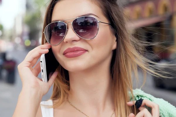 Porträt eines lächelnden Mädchens, das mit dem Handy spricht. — Stockfoto