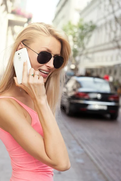 Lachende blonde dame praten via de telefoon. — Stockfoto