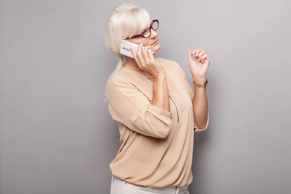 Portret van aantrekkelijke senior vrouw met mobiele telefoon. — Stockfoto