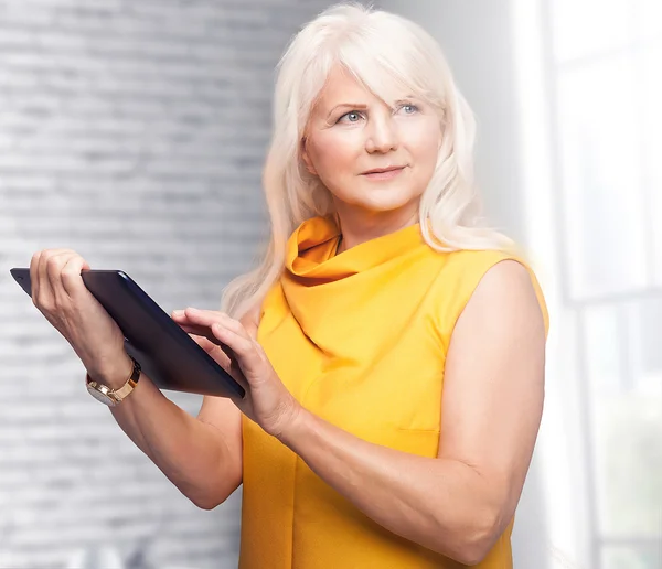 Porträt einer attraktiven Seniorin mit Tablet. — Stockfoto