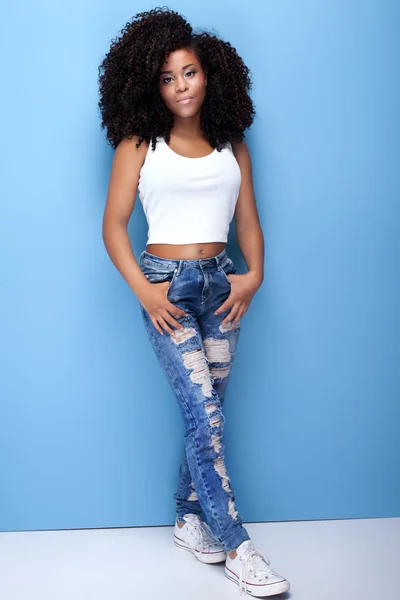 Chica joven con afro posando sobre fondo azul . — Foto de Stock