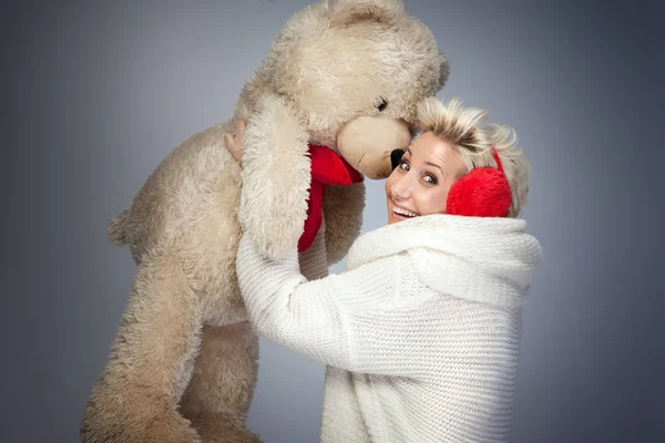 Smiling woman with teddy bear.