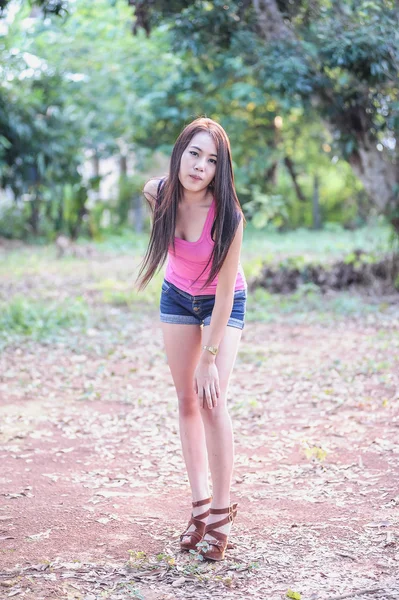 Pembe yelek ve kısa kot giyen Asya genç kadın — Stok fotoğraf