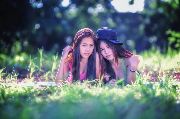 草の上に横たわる 2 つのアジアの若い女性 — ストック写真