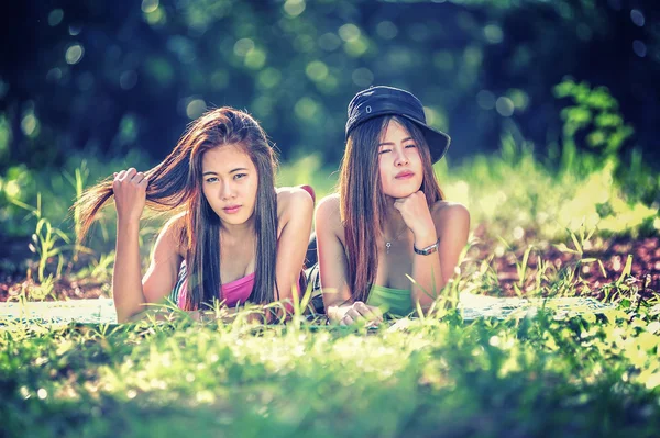 Zwei junge asiatische Frauen liegen auf Gras — Stockfoto