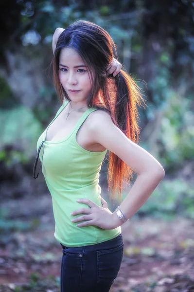 Асия молодая женщина в зеленом жилете в парке — стоковое фото