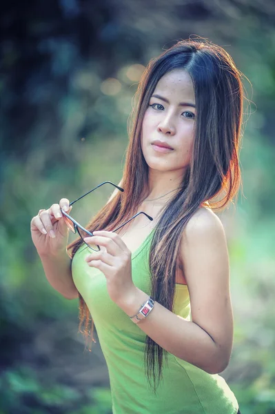 Asia joven Mujer vistiendo chaleco verde en el parque — Foto de Stock