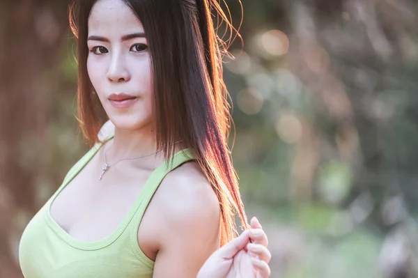 Asiatico giovane donna indossare verde gilet su parco — Foto Stock