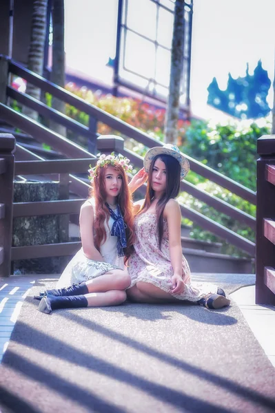 Två Asien unga kvinnor sitter på terrassen — Stockfoto