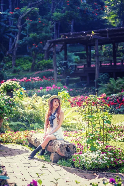 Азия молодых женщин, сидящих в цветущем саду — стоковое фото