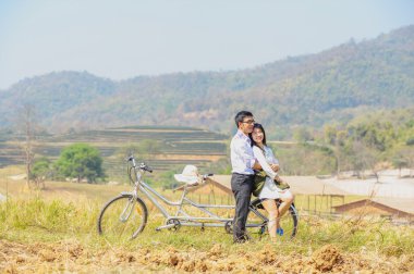 Asya çift doğa bisikletle kucaklayan