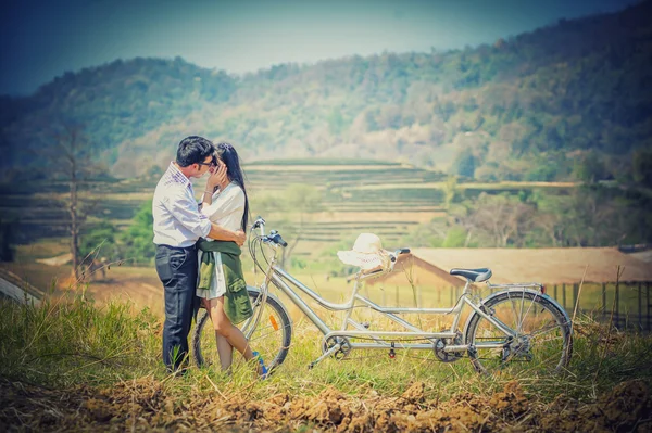 Ásia Casal abraçando com bicicleta na natureza — Fotografia de Stock