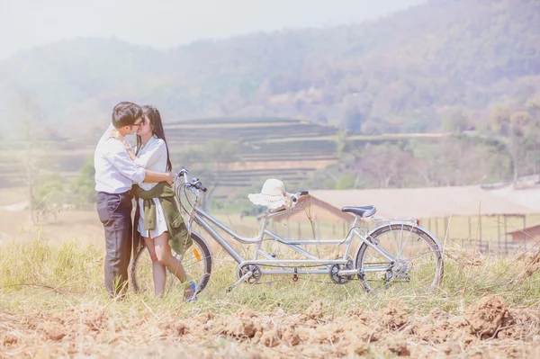 Ásia Casal abraçando com bicicleta na natureza — Fotografia de Stock