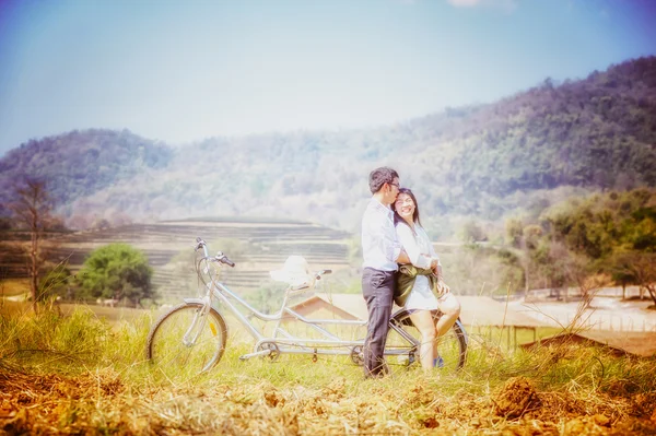 Asiatisches Paar umarmt sich mit dem Fahrrad in der Natur — Stockfoto