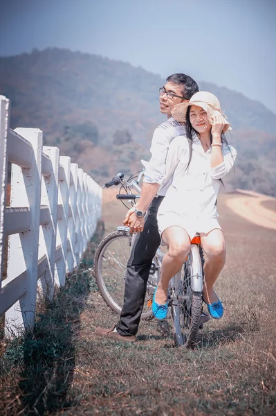 Azië paar met fiets en berg achtergrond — Stockfoto