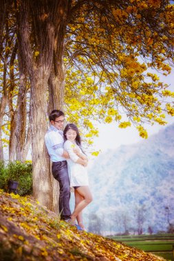 Asya mutlu çift ayakta ağacının altında