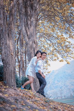 Asya mutlu çift ayakta ağacının altında