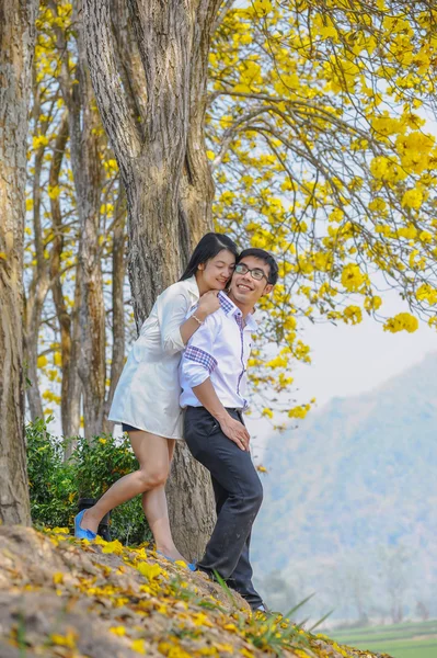 Ásia feliz casal de pé sob a árvore — Fotografia de Stock