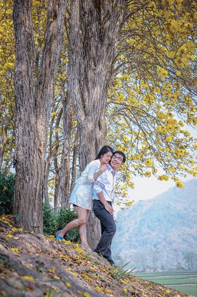 Asia felice coppia in piedi sotto albero — Foto Stock