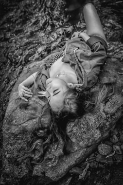 Asya güzel genç seksi kız kayanın üzerinde uzanmış 