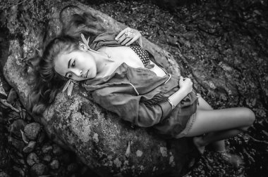 Asya güzel genç seksi kız kayanın üzerinde uzanmış 